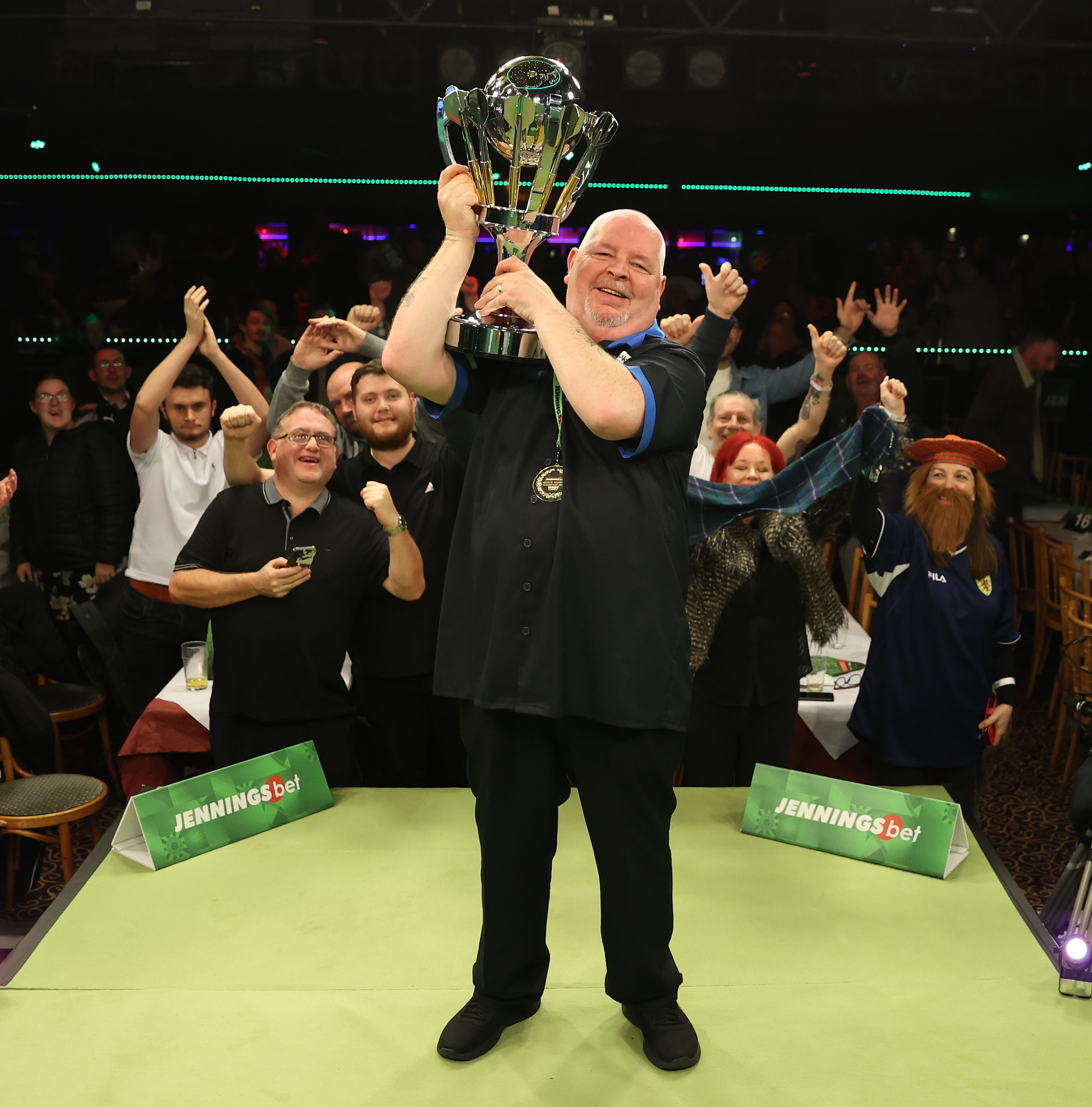 Robert Thornton lifting a trophy with cheering spectators behind